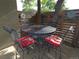 Outdoor patio with metal table and chairs with red cushions at 9075 W 66Th Ave, Arvada, CO 80004