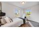 Bright bedroom featuring a comfortable bed, modern decor, and dual windows at 3249 W Alaska Pl, Denver, CO 80219