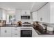 Modern kitchen featuring stainless steel appliances, dark countertops, white subway tile backsplash, and bright white cabinetry at 3249 W Alaska Pl, Denver, CO 80219