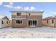 Backyard with a two-story house, sliding glass doors, a snowy yard, and an open sky at 9122 Telluride Ct, Commerce City, CO 80022