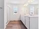 Modern bathroom features dual vanity sinks, a glass-enclosed shower, and wood-style floors at 9122 Telluride Ct, Commerce City, CO 80022