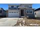 Two-story home with gray siding, stone accents, and a two-car garage at 9122 Telluride Ct, Commerce City, CO 80022