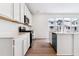 Modern kitchen with white cabinets, island with sink, and stainless steel appliances at 9122 Telluride Ct, Commerce City, CO 80022