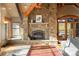 Cozy living room with a stone fireplace, hardwood floors, and a bright window with lots of natural light at 174 Sage Dr, Breckenridge, CO 80424