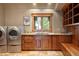 Well-equipped laundry room with stainless steel washer and dryer, sink, and ample wooden cabinetry at 174 Sage Dr, Breckenridge, CO 80424