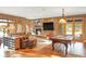 Spacious living room with stone fireplace, large windows, comfortable seating, and a pool table at 174 Sage Dr, Breckenridge, CO 80424