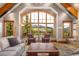 Elegant living room with vaulted ceilings, a large arched window showcasing stunning mountain views and luxury furnishings at 174 Sage Dr, Breckenridge, CO 80424