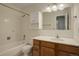 This bathroom has a bath and shower, white tiling, vanity with cabinet space, and ample lighting at 2466 S Vaughn Way # A, Aurora, CO 80014