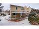 Two-story townhome with snow covered yard and a covered porch at 2466 S Vaughn Way # A, Aurora, CO 80014