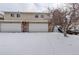 Townhome with a two-car garage and snow-covered driveway at 2466 S Vaughn Way # A, Aurora, CO 80014