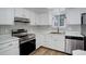 Bright kitchen featuring white cabinetry, stainless steel appliances, and stylish black and white backsplash at 2466 S Vaughn Way # A, Aurora, CO 80014