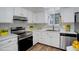 Bright kitchen featuring white cabinetry, stainless steel appliances, and stylish black and white backsplash at 2466 S Vaughn Way # A, Aurora, CO 80014