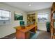 Bright home office with a large wooden desk, ample natural light, and stylish yellow bookshelves at 2466 S Vaughn Way # A, Aurora, CO 80014