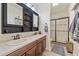 Bright bathroom with a double sink vanity, dark wood cabinets, and walk-in shower at 3828 Mighty Oaks St, Castle Rock, CO 80104