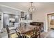 Dining area with a rustic wooden table, an ornate light fixture, and views into the kitchen at 725 Osceola St, Denver, CO 80204