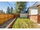 Backyard featuring a fenced yard, healthy green lawn, a storage shed, and lush greenery at 12475 W 38Th Ave, Wheat Ridge, CO 80033