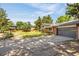 Two-car garage with long driveway and view of the home's exterior, brick, and siding at 12475 W 38Th Ave, Wheat Ridge, CO 80033