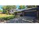 View of a brick and siding home with well-maintained lawn, mature trees, and attached two car garage at 12475 W 38Th Ave, Wheat Ridge, CO 80033