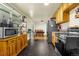 Kitchen with wood cabinets, black appliances, and a view to the dining area at 12475 W 38Th Ave, Wheat Ridge, CO 80033