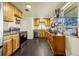 Kitchen features wood cabinets, black appliances, and ample countertop space at 12475 W 38Th Ave, Wheat Ridge, CO 80033