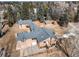 Aerial view of the two-story home featuring a driveway and lots of tall trees at 3720 E Quincy Ave, Cherry Hills Village, CO 80113