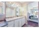 Bathroom includes a double sink vanity with great lighting and a mirror with a view of the bedroom at 17855 Lake Side Dr, Monument, CO 80132