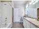 Bathroom featuring a tub and shower combination, double sinks, and white cabinets and doors at 17855 Lake Side Dr, Monument, CO 80132