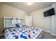 Bright bedroom with a king bed featuring a decorative headboard and a wall-mounted television at 17855 Lake Side Dr, Monument, CO 80132