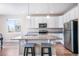 Modern kitchen with an island with barstool seating, stainless steel appliances, and ample counter space at 17855 Lake Side Dr, Monument, CO 80132