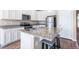 This kitchen offers granite countertops, stainless steel appliances, white cabinets and island seating at 17855 Lake Side Dr, Monument, CO 80132