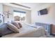 Bright main bedroom featuring a large window, TV, light gray dresser, and decor tree decal at 17855 Lake Side Dr, Monument, CO 80132