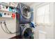 Modern laundry room with stacked washer and dryer units and practical storage shelves at 720 Independence Dr, Longmont, CO 80504