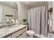 Cozy bathroom features a vanity with granite countertop and a tub with a grey shower curtain at 6805 Zebra Grass Ln, Parker, CO 80138