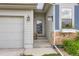 Inviting entrance featuring brick accents, stone pathway, fresh landscaping, and a glass paneled front door at 6805 Zebra Grass Ln, Parker, CO 80138