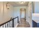 Bright hallway with wood floors, staircase with white rails, arched doorway, and modern light fixture at 6805 Zebra Grass Ln, Parker, CO 80138