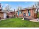 Beautiful backyard featuring a patio with a fire pit, table with umbrella, and grassy area at 916 Adams St, Denver, CO 80206