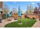 Landscaped backyard with green grass, stone patio, outdoor seating, and wooden fence at 916 Adams St, Denver, CO 80206
