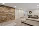 Spacious basement living room with carpet floors, white walls, and a stone accent wall at 916 Adams St, Denver, CO 80206