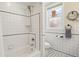 Bright bathroom featuring a shower-over-tub, classic black and white tiles, and a window at 916 Adams St, Denver, CO 80206