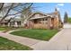 Beautiful brick home featuring a covered porch, manicured lawn, and classic architectural details at 916 Adams St, Denver, CO 80206