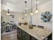 Kitchen island with granite countertop, adjacent to a cozy breakfast nook and stairs at 916 Adams St, Denver, CO 80206