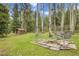 Scenic backyard featuring a fire pit and cozy cabin with birch trees and wooded landscape at 2654 Sinton Rd, Evergreen, CO 80439