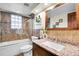 Bright bathroom featuring granite countertop, tiled shower, and glass block window for natural light at 2654 Sinton Rd, Evergreen, CO 80439