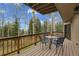 Open-air deck with seating offers serene views of towering trees and a lush, green lawn at 2654 Sinton Rd, Evergreen, CO 80439