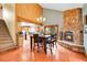 Open-concept dining area with wood floors, stone fireplace, chandelier lighting, and staircase leading to the upper level at 2654 Sinton Rd, Evergreen, CO 80439