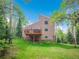 Exterior of home featuring wood siding, a deck, and mature aspen trees on a lush green lawn at 2654 Sinton Rd, Evergreen, CO 80439
