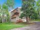 Three-story home with private decks, garage, driveway and inviting entryway nestled among mature trees at 2654 Sinton Rd, Evergreen, CO 80439