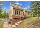Charming home with tiered deck, landscaped yard and natural light, nestled in a wooded setting against a blue sky at 2654 Sinton Rd, Evergreen, CO 80439