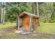 Rustic log cabin with a wooden door and window, surrounded by lush greenery and mature trees at 2654 Sinton Rd, Evergreen, CO 80439