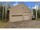 Spacious two-car garage with separate entrance, neutral siding, and driveway at 2654 Sinton Rd, Evergreen, CO 80439